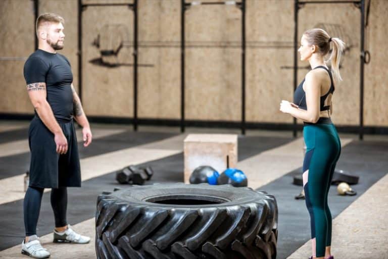 Couple training with tire n the gym