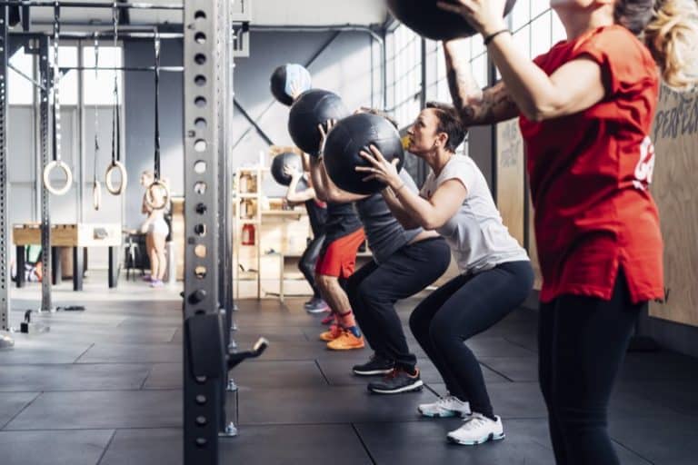 Group of people in gym using medicine balls