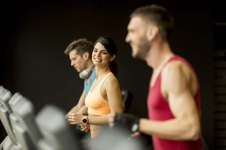 young people running on treadmills in modern gym